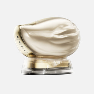 TAFITIE Conch ultrasonic facial device on its clear charging base, side view